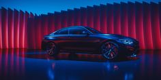 a black car parked in front of a red wall