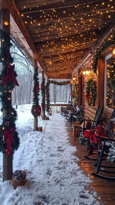 a porch covered in snow with christmas lights and wreaths on the front, along with rocking chairs