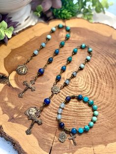 Collection of rosaries, bracelets, and chaplets handcrafted with high quality blue gemstones and accented with a solid bronze crucifix and Saint Anthony medal.  All beads used are made from natural gemstones. Therefore, each bead is unique and might have slight color difference or imperfections.  Size & Customization Please message me for alternate size options. I am happy to accommodate custom orders. Please message me with your specific requests.  Care Many gemstone, crystal, and wood beads sh Rosary Bracelet Catholic, Catholic Rosary Bracelet, Chaplet Rosary, St Anthony, Saint Anthony, Catholic Jewelry, Catholic Rosary, Rosary Bracelet, Rosary Catholic