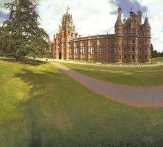 a large brick building sitting on top of a lush green field