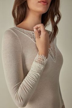 Long-sleeved modal cashmere ultralight shirt enhanced with lace. Feminine V-neck Tops With Lace Sleeves, Elegant V-neck Lace Top For Fall, Elegant White Blouse For Loungewear, Feminine V-neck Top With Lace Sleeves, Spring V-neck Top With Lace Cuffs, Elegant Viscose Tops For Loungewear, Elegant Long Sleeve Tops For Layering, Chic Tops With Delicate Lace For Daywear, Lace Trim Tops For Fall Loungewear