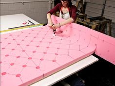 a woman working on a pink piece of furniture