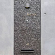 a sign on the side of a building that says pitt boon 78th street and is next to a fire hydrant