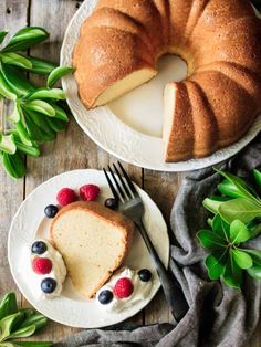 a bundt cake on a plate with berries next to it and a slice cut out