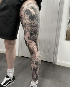 a man's leg with a bear and wolf tattoo on it, while standing in front of a door