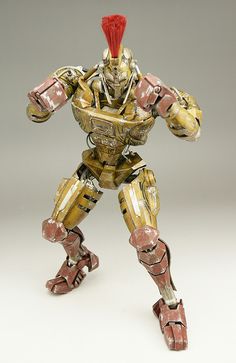 an action figure made out of gold and red material with two hands on one arm