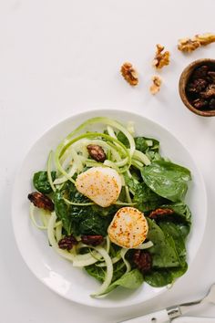 a white plate topped with greens and hard boiled eggs