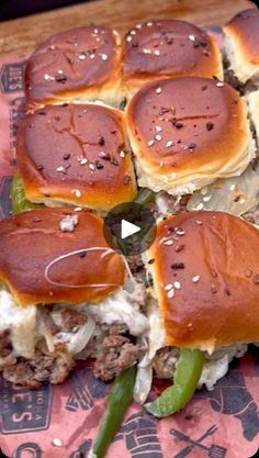 several sliders with cheese and green beans on them sitting on top of a piece of paper