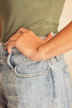 a person with a small tattoo on their left arm and the other hand in her pocket