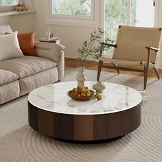 a living room filled with furniture and a white marble coffee table in front of a couch