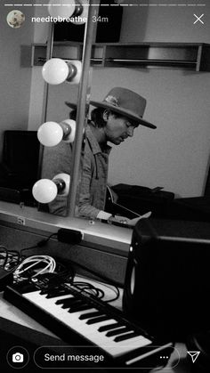 a man sitting at a keyboard in front of a mirror