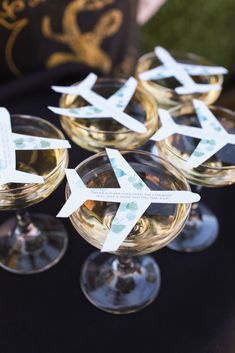 four wine glasses with labels on them sitting on a table