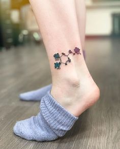 a woman's foot with a small tattoo on the side of her leg,