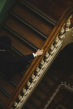 a man in a tuxedo climbing up the stairs with his hand on the railing