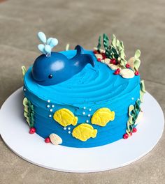 a blue whale cake sitting on top of a white plate