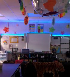 an empty classroom with decorations hanging from the ceiling and a tiger stuffed animal on the floor