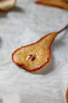 a piece of fruit sitting on top of a white tablecloth covered in wax paper