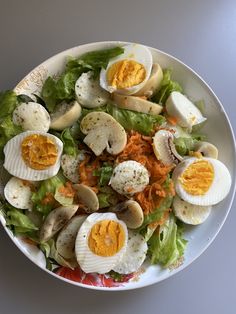 a salad with hard boiled eggs and lettuce in it on a white plate