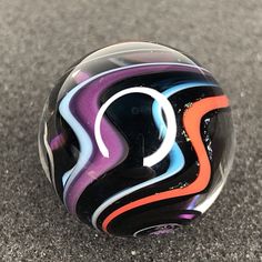 a colorful glass ball sitting on the ground