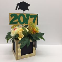 a bouquet of flowers in a vase with a graduation hat on top that reads 207