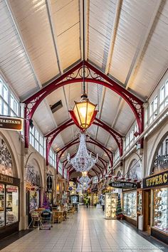 an empty shopping mall with chandeliers hanging from it's ceiling and windows