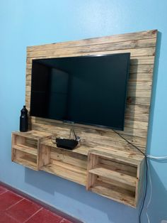 a flat screen tv mounted to the side of a wooden entertainment center in a room