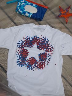 a white t - shirt with red, white and blue sprinkles on it