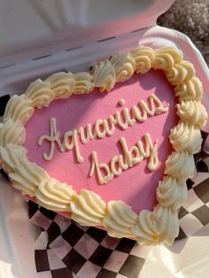 a heart shaped cake with the words aquarius baby written in frosting on it