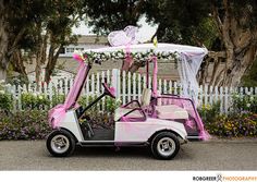 a pink and white golf cart decorated with flowers