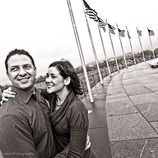 a man and woman standing next to each other in front of flags on the ground