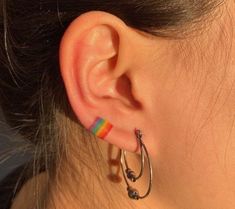 a close up of a person's ear with a pair of hoop earrings on it