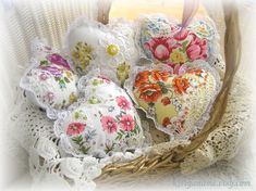 a basket filled with lots of different types of heart shaped pillowes on top of a table