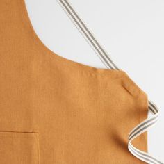 an apron is shown with the straps down and one side has a white stripe on it