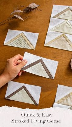 someone is working on some quilts that are sitting on a table with scissors and thread