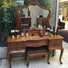 an ornate wooden vanity with mirrors and bottles on it