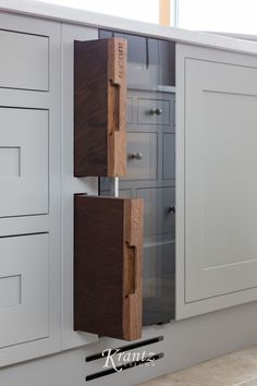 a kitchen with white cabinets and wooden drawers