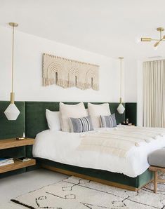 a bedroom with a large bed and green headboard on the wall next to a white rug