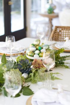 an easter table setting with eggs and greenery