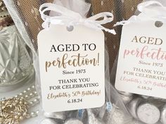 two tags with the words aged to perfection and thank you for celebrating are shown in front of some other items