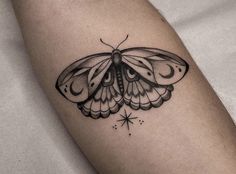 a small black and white butterfly tattoo on the right arm, with stars around it