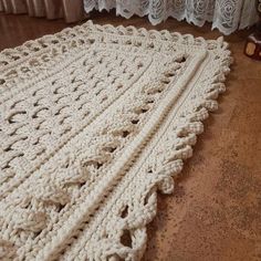 a crocheted blanket is laying on the floor