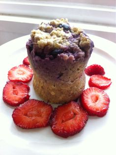 there is a muffin with strawberries on the plate