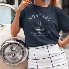 Featuring an elegant nautical design, the Montauk Sailing Club T Shirt is perfect for any occasion. The shirt's unique design evokes a retro luxury aesthetic that is comfortable and stylish. Whether you're a sailor or you're simply a lover of all things Montauk, this cozy tee is a must-have addition to your wardrobe. Give it as a gift to someone special your life or treat yourself to this unique and timeless piece. * PRODUCT DETAILS * ♥ Double needle stitching on all seams. The garment is sewn a Classic Luxury T-shirt With Logo, Cheap Nautical Style Crew Neck T-shirt, Cheap Nautical Crew Neck T-shirt, New York Preppy, Shirt Old Money, Preppy Stuff, Sport Sweater, Retro Sports, Club T Shirt