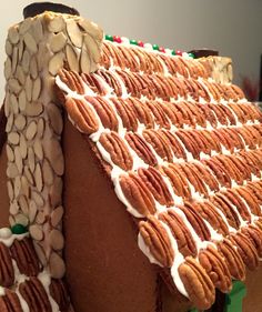 a gingerbread house with white frosting and almonds