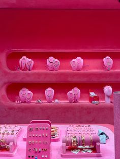 a pink display case filled with lots of jewelry