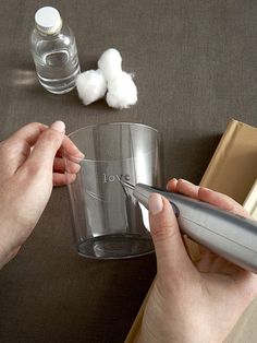 a person holding a glass with cotton floss next to it