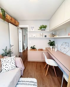 a living room filled with furniture and lots of shelves next to a desk on top of a hard wood floor