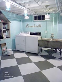 an industrial laundry room with black and white checkered flooring, washer and dryer