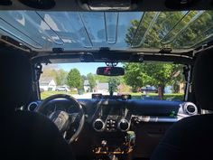 the interior of a vehicle with dashboard lights and steering wheel controls, seen from inside