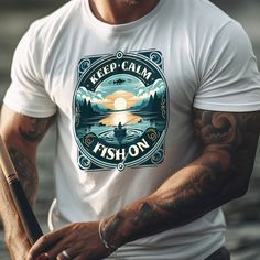 Evoke the tranquility of dawn on the water with our Keep Calm Fish On Tee. This shirt captures the essence of peaceful mornings spent fishing, with a vintage style that appeals to the soul of anglers. 🌅🎣 🛶 Shirt's Best Qualities: Beautiful lake fishing scene with a calming sunrise Soft, breathable fabric perfect for a day by the water Vintage design that reflects a love for the fishing tradition A soothing mantra for the passionate fisherman Ideal for those who find their zen with a line in the lake Slip into this tee for your early fishing trips or casual outings and carry the 'Keep Calm Fish On' spirit with you. It's more than a shirt; it's a reminder to relax and enjoy the simple pleasures of fishing. Cast your line and let the rest of the world fade away. 🌲🐟 This classic unisex je Summer Fishing Tops With Crew Neck, White Graphic Print Tops For Fishing, Graphic Print Shirt For Fishing In Summer, Fishing Scene, Scene Shirt, Lake Fishing, Top Vintage, Beautiful Lakes, Fishing Trip